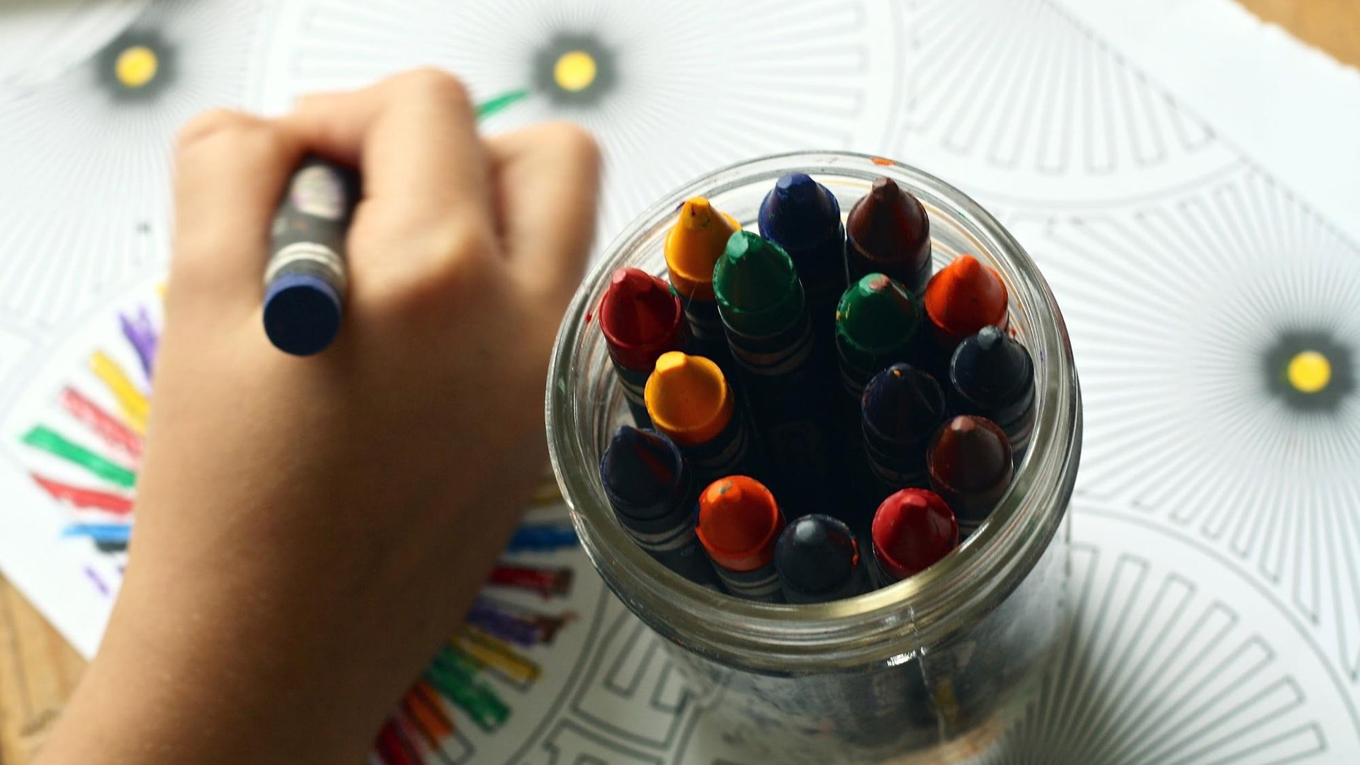 Child coloring an illustration with crayons