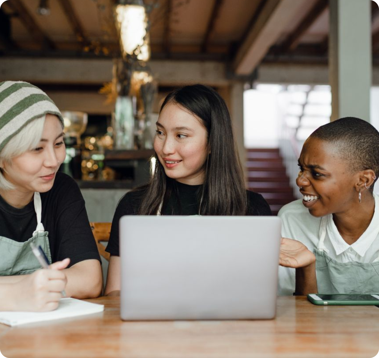Three people collaborating over designs in front of laptop