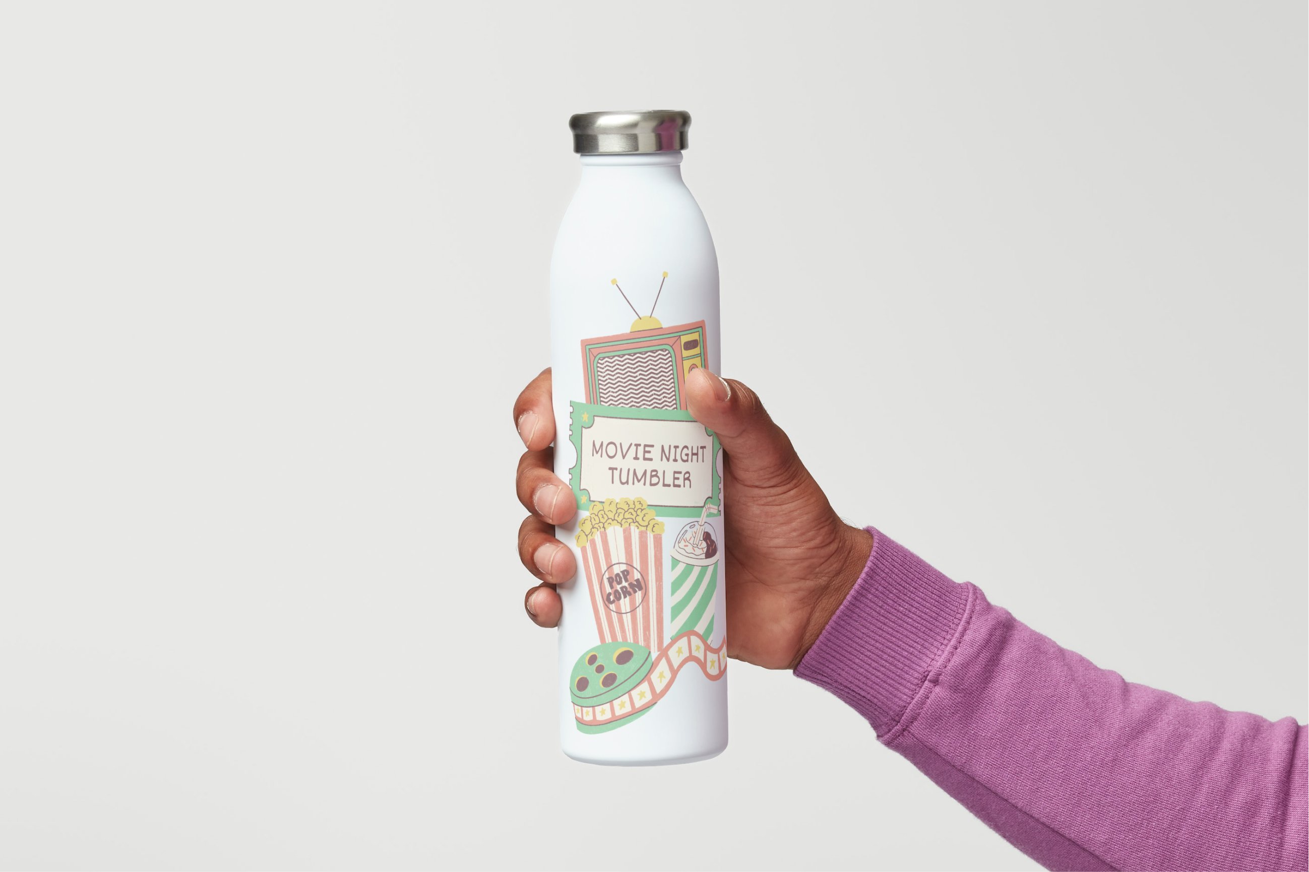Main tenant une bouteille personnalisée blanche avec des illustrations sur le thème du cinéma