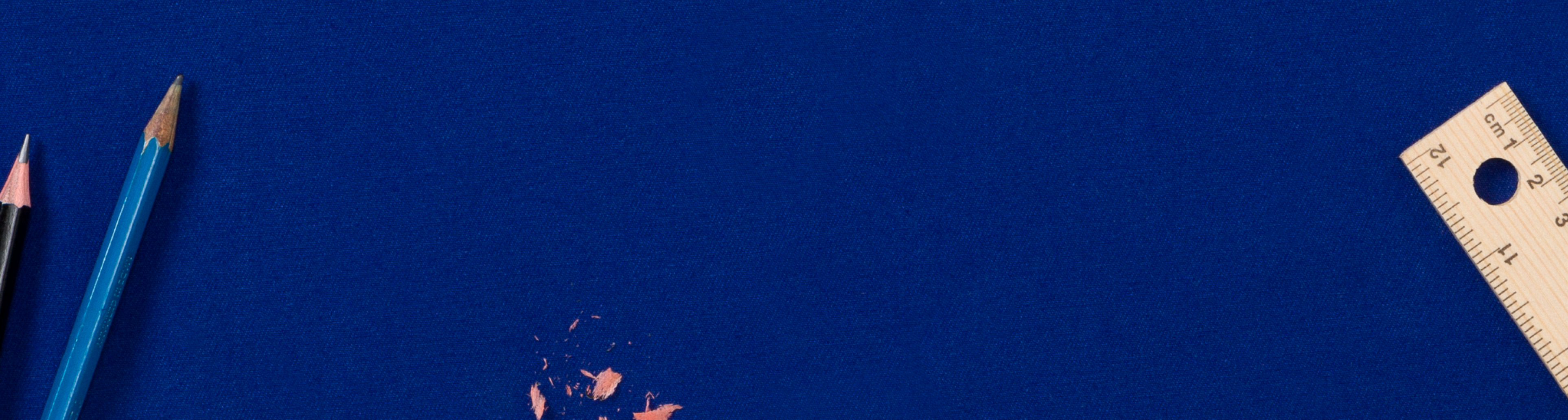 Pencils, pencil shavings and wooden ruler flat lay on dark blue background