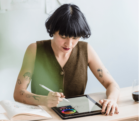 A person writing down notes on their tablet