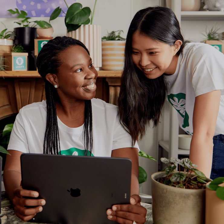 A person showing another person their iPad