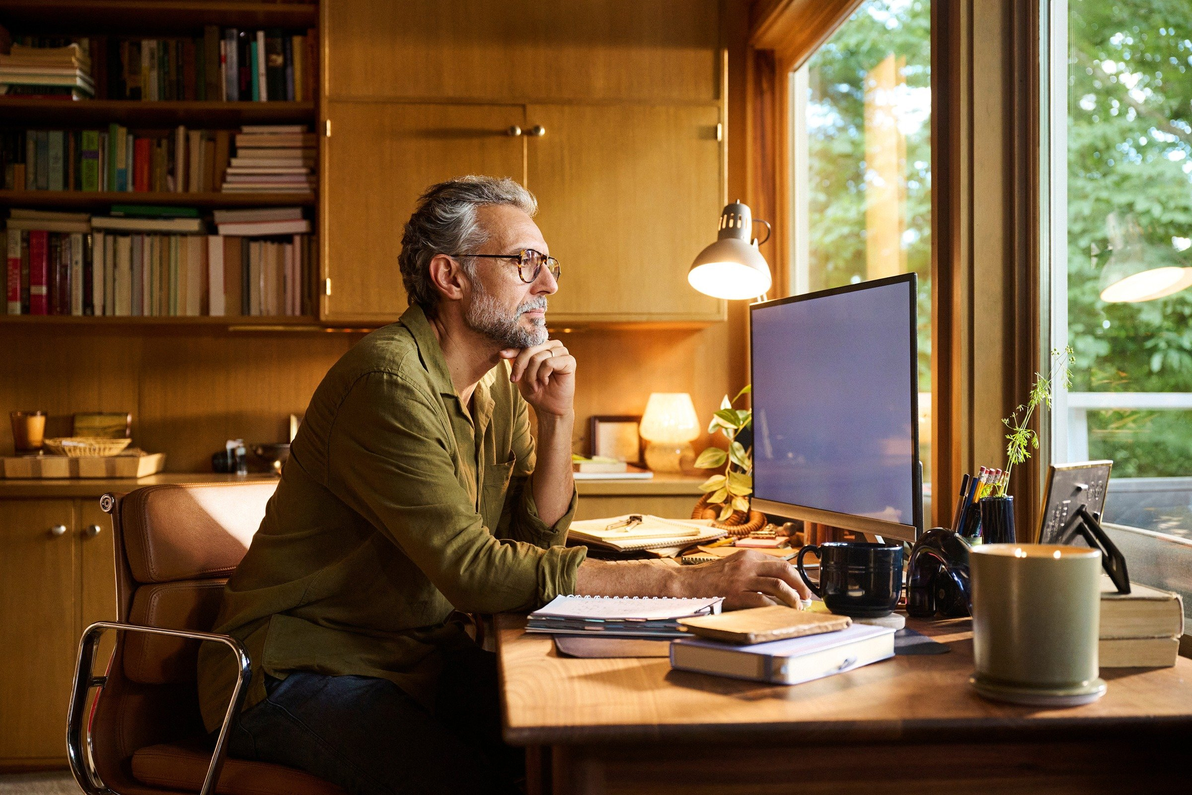 Photo d’homme travaillant sur un ordinateur défloutée avec l’outil pour déflouter une image en ligne de Canva