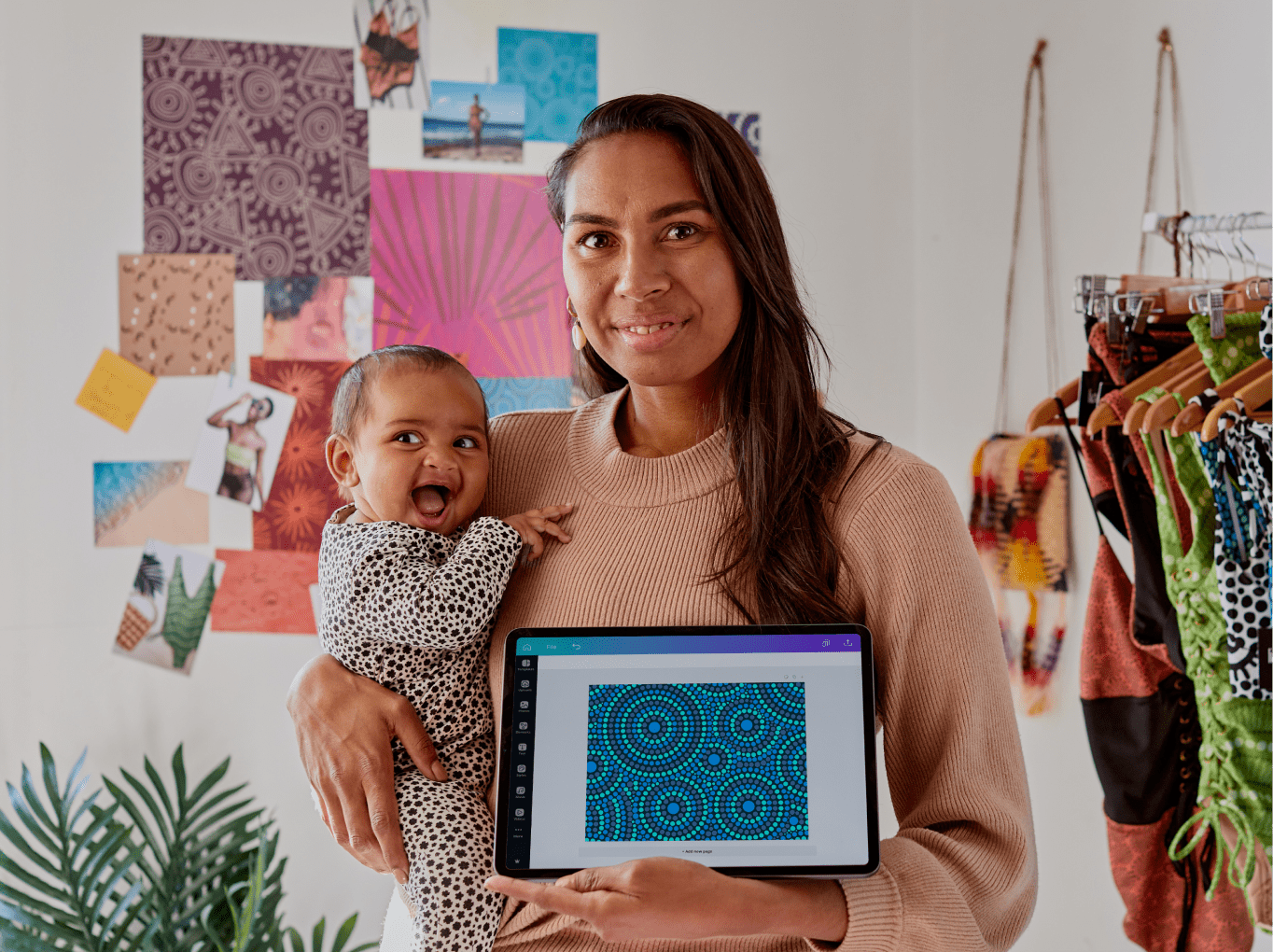 A person holding a baby presenting a design made using Canva